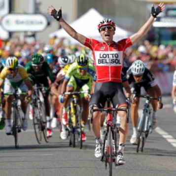 France's Tony Gallopin manages to stay ahead of the spring pack, rear, as he crosses the finish line to win the eleventh stage of the Tour de France cycling race over 187.5 kilometers (116.5 miles) with start in Besancon and finish in Oyonnax, France, Wednesday, July 16, 2014. (AP Photo/Peter Dejong)